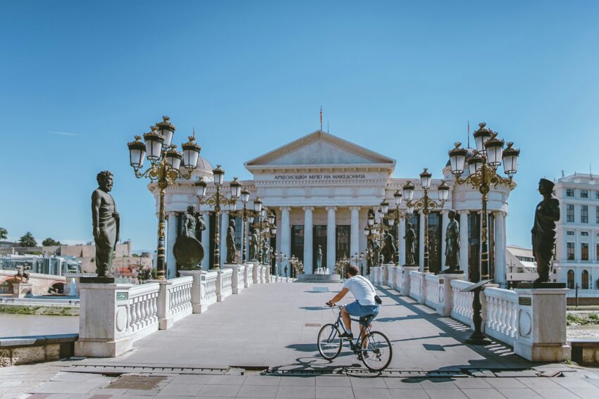Man on bike riding across bridge to Macedonia Museum